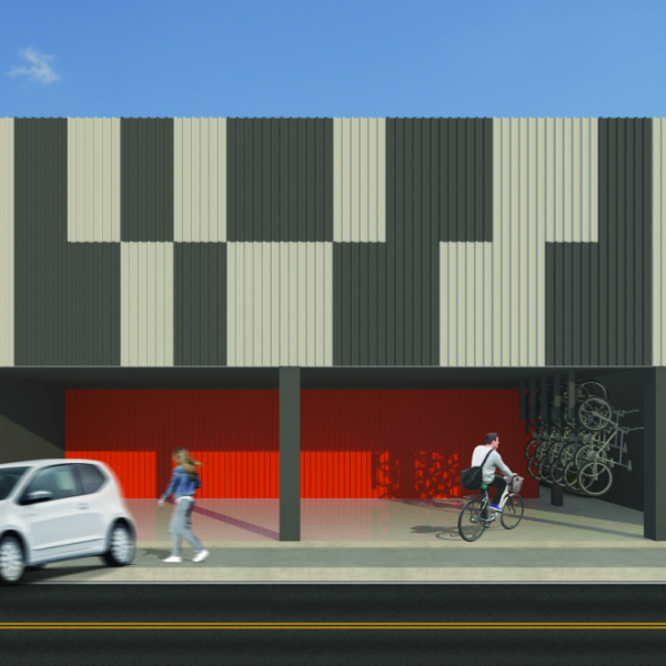 Vista da fachada frontal onde foi proposto um painel de telhas metálicas com interessante apelo visual, criado pela alternância de telhas pretas e galvanizadas, no segundo plano optou-se pela telha vermelha. Outro ponto importante de ressaltar é o espaço destinado ao bicicletário, ao lado das vagas cobertas destinadas aos clientes.