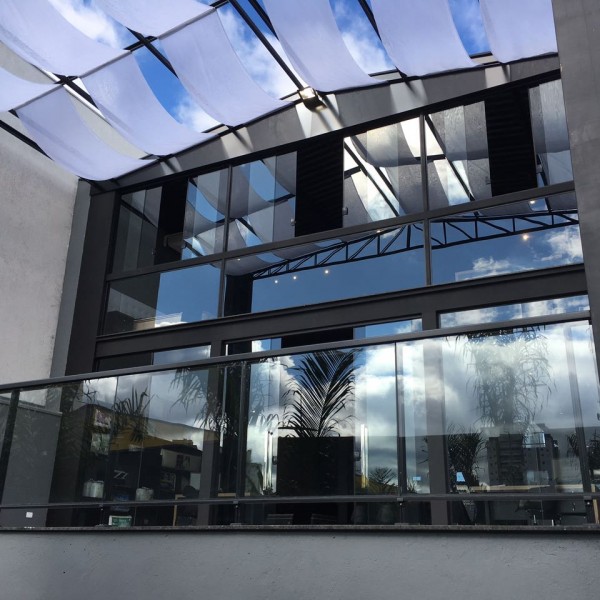 Para o controle da incidência solar da fachada posterior foram utilizados na cobertura faixas de tecido tipo voal branco.