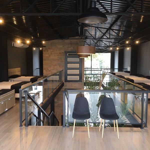 Vista da área de estar do mezanino e dos expositores dos materiais utilizados nos colchões vendidos.