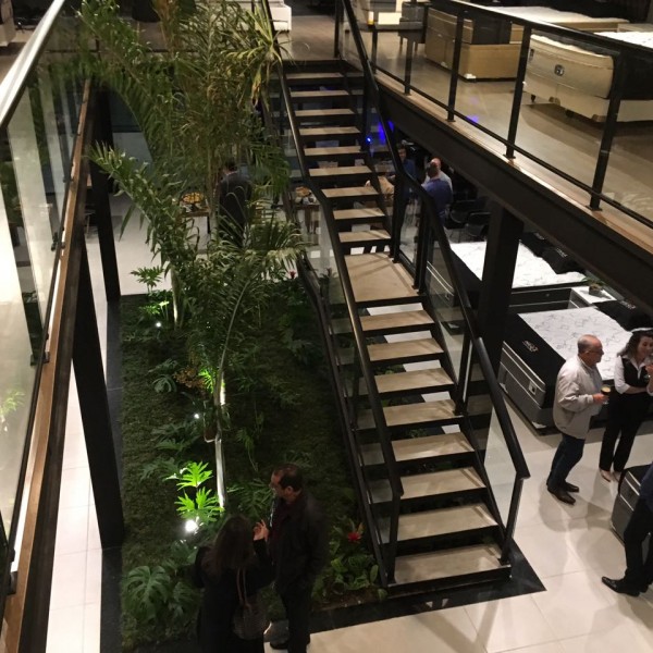 Vista noturna superior da escada e do jardim interno.